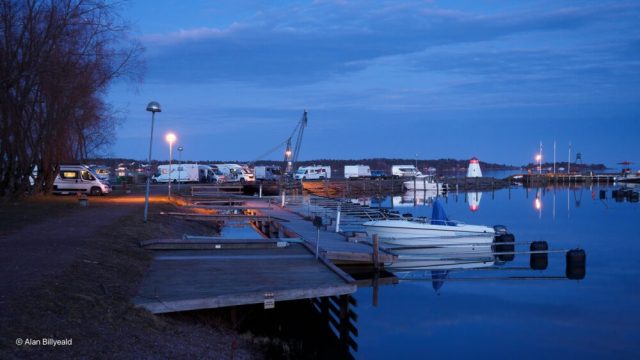 Et stemningsfullt nattbilde som viser en rolig havn med flere båter, tatt i skumringen eller tidlig natt.